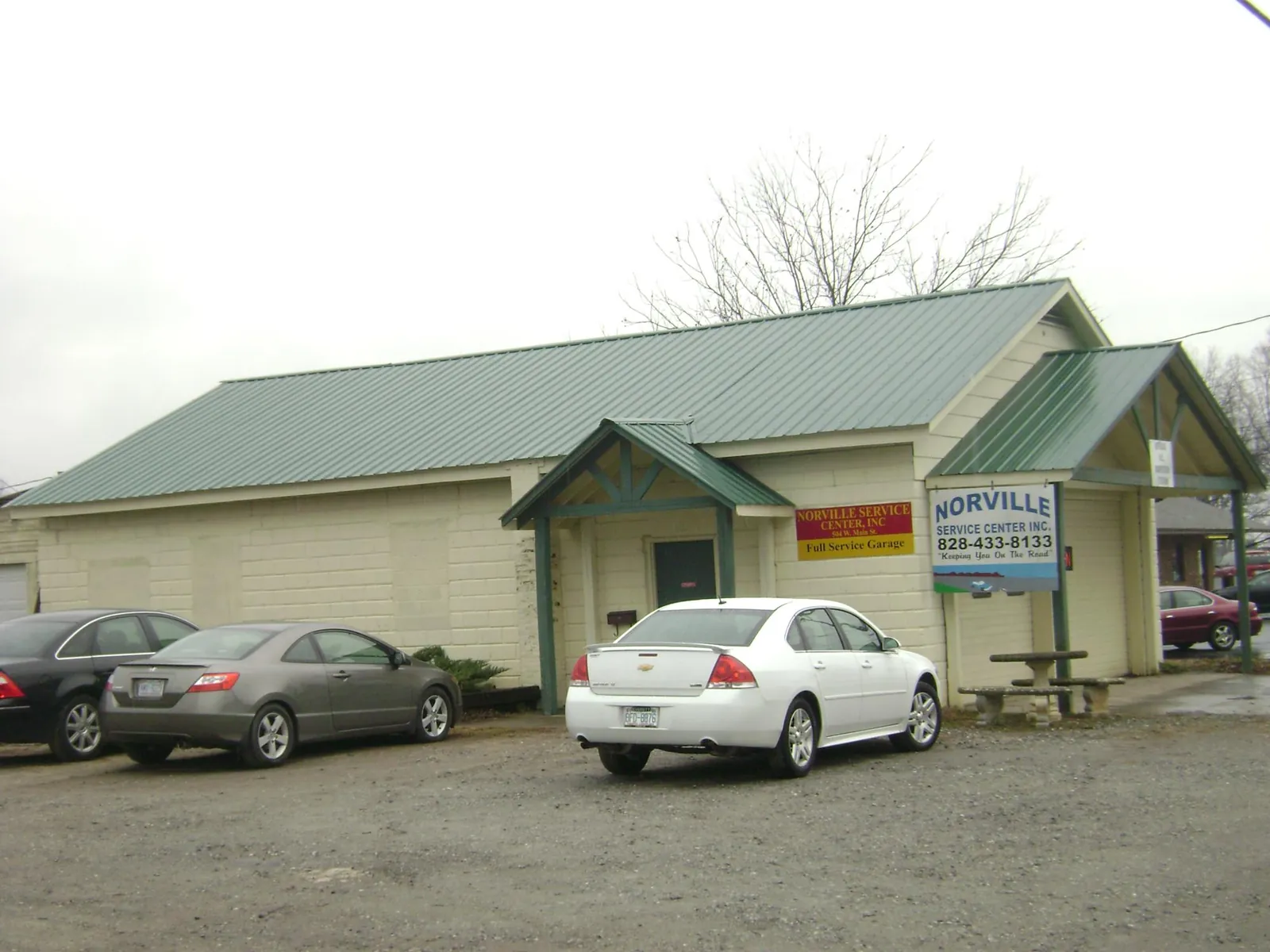 Green metal roof on a service garage with a covered entry in Milford